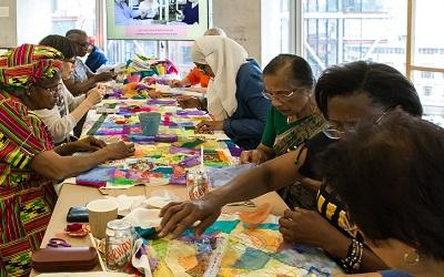 Article photo image credit: Marcia Chandra, a Stitch in Time, Who Are We? Project, 2018. Courtesy of Counterpoints Arts. Image of a group of women sewing together.