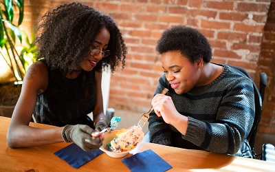 Two women enjoy ice cream together in a cafe