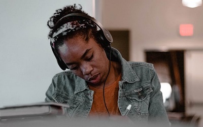A student works at a desk with headphones on
