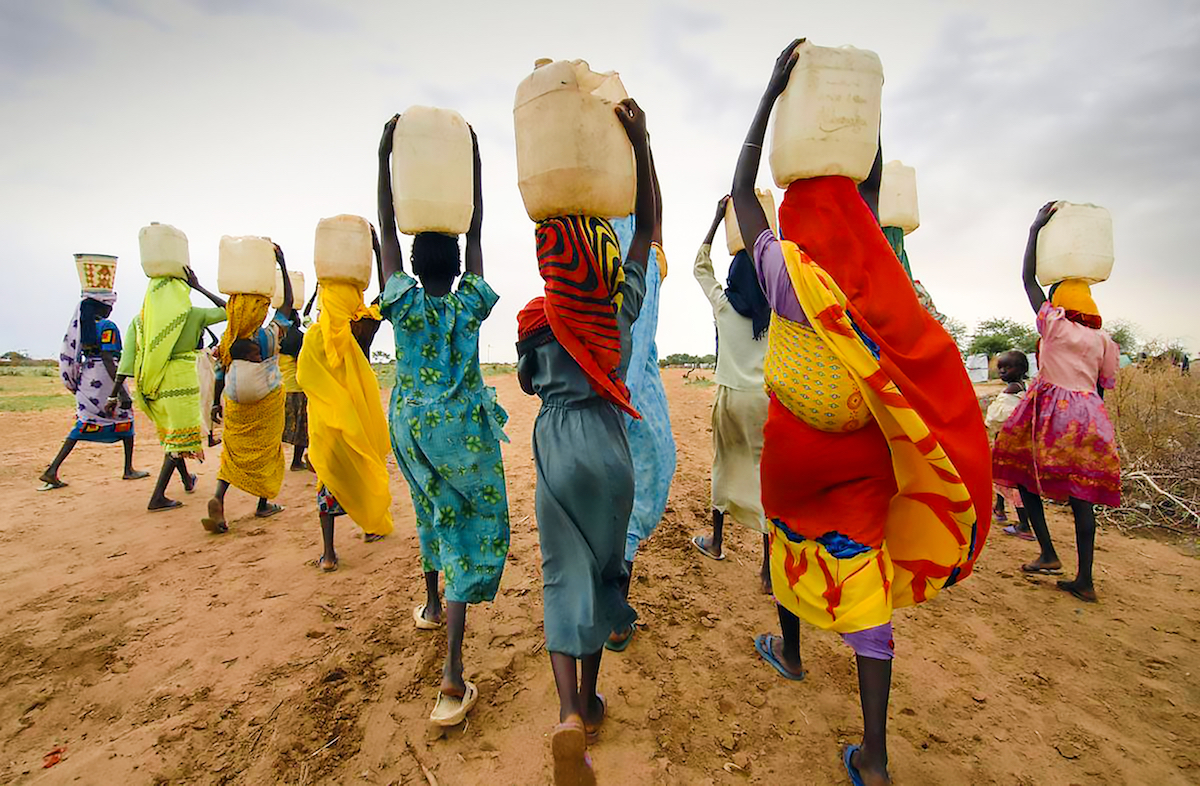Photo of women in Tanzania carrying water jars