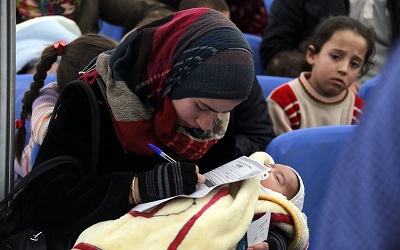 A Syrian mother holding her baby, taken in Lebanon, Photo: Mohamed Azakir / World Bank