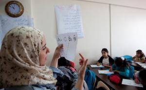 photo of teacher teaching refugee children