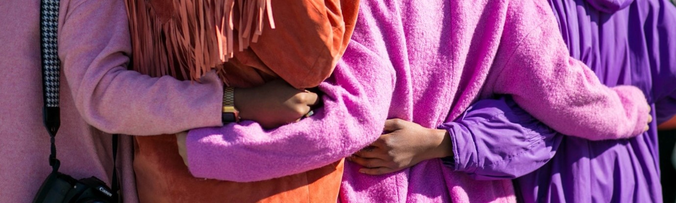 a group of people hugging with their backs to us