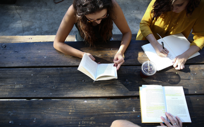 Three girls studying at a table outdoors
