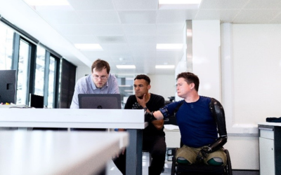 three men looking at a computer