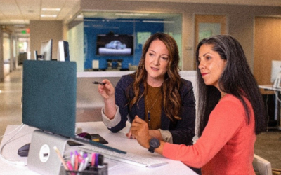 two women discussing something at a laptop