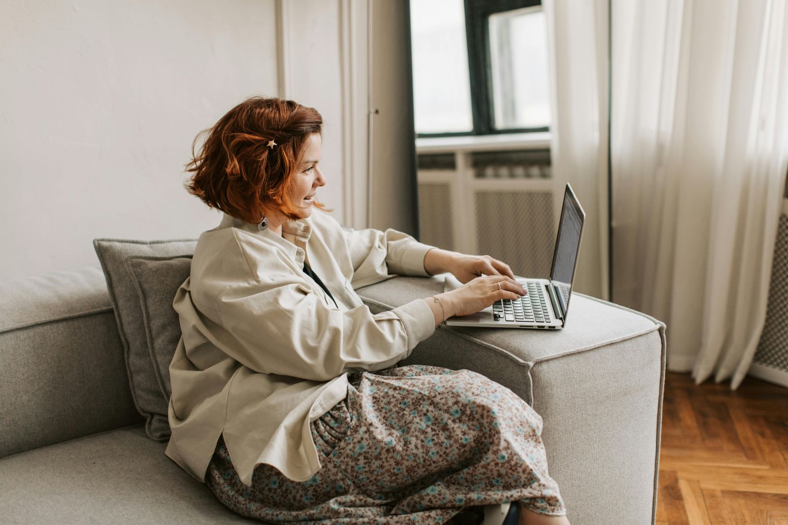 A person sitting on a couch using a computer. Photo by Vlada Karpovich: https://www.pexels.com/photo/woman-sitting-on-a-sofa-using-laptop-7153910/