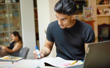 Student working at home with books and a laptop