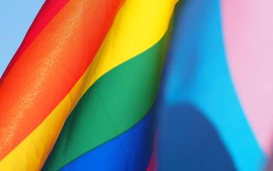 A close up shot of the Pride Progress flag that is sailing in the wind.