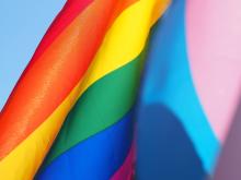 A close up shot of the Pride Progress flag that is sailing in the wind.