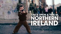 A young boy on the streets of Belfast pointing a gun towards the camera. The text to his right reads 'Once upon a time in Northern Ireland'.