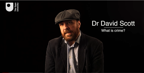 A man called Dr David Scott sitting against a black background.