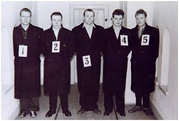 A black and white picture of five white men in a lineup wearing black suits numbered 1-5.