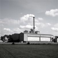 A factory with a chimney with smoke coming out of it.