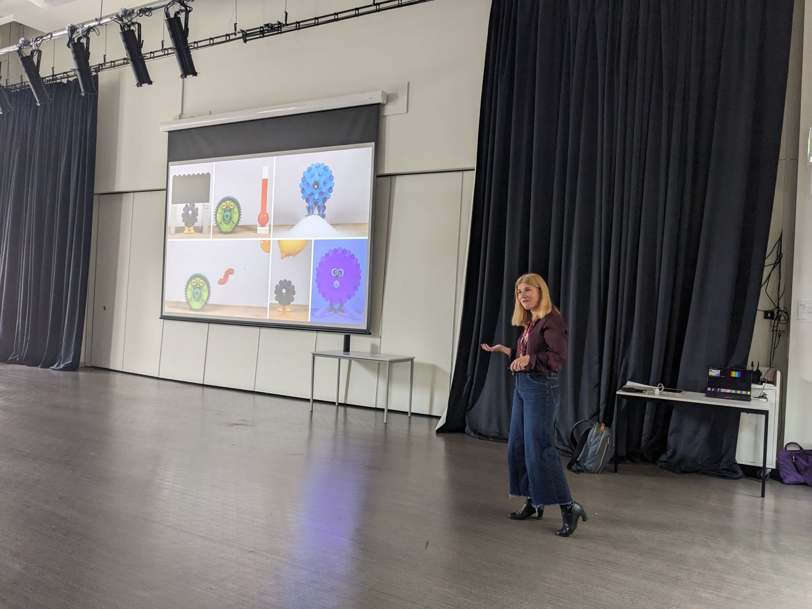 Karen giving a talk with a large screen behind her showing her slides.