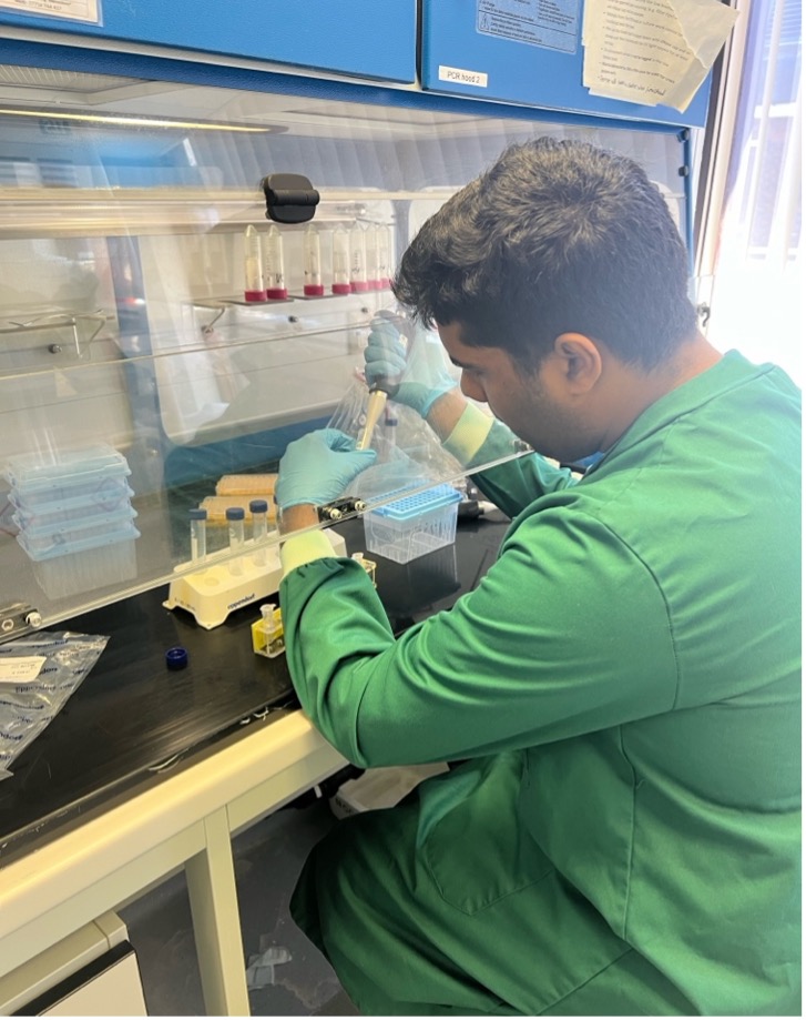 Ryan Kingston using a pipette to combine samples from microbial enrichments with fluorescence dyes.