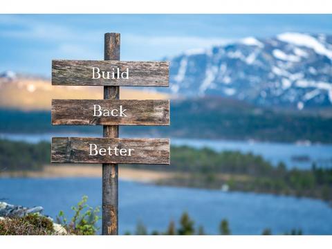 picture of mountains and a lake and a wooden sign that says build back better