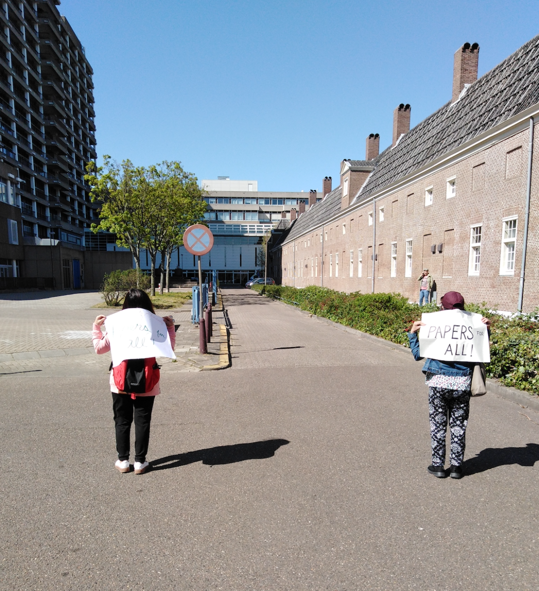 two women walk along the pavement of an empty Hague street