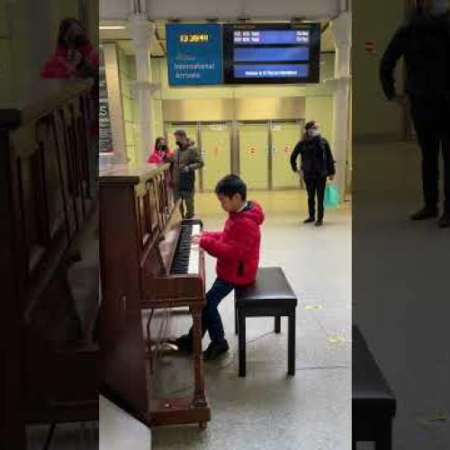 A hongkong boy playing piano at Pancras train station