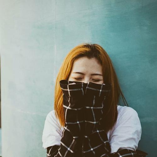 women with hands coving half of her face