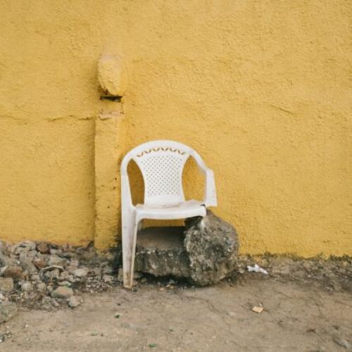 white chair in front of yellow wall