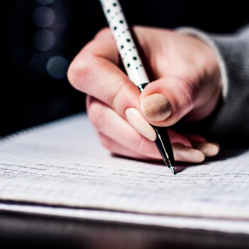 a hand writing on a paper