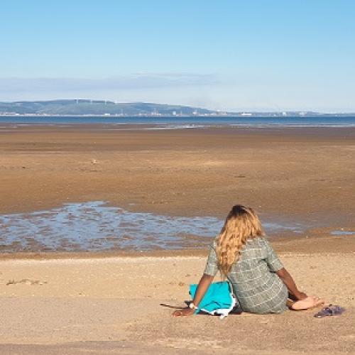 women sitting on Welsh beach