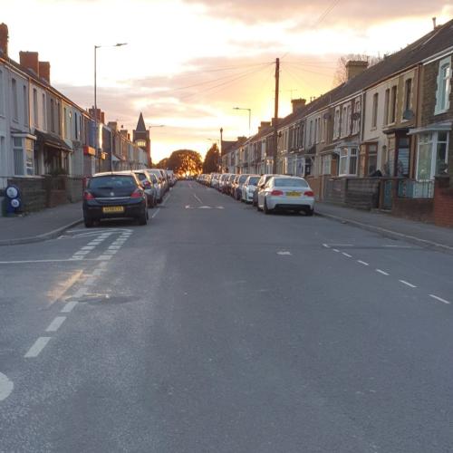 A very quiet street is shown with a beautiful sky behind it