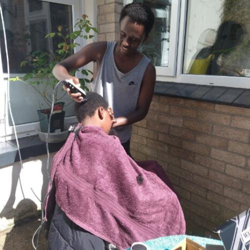 A Kenyan refugee family learning hairdressing