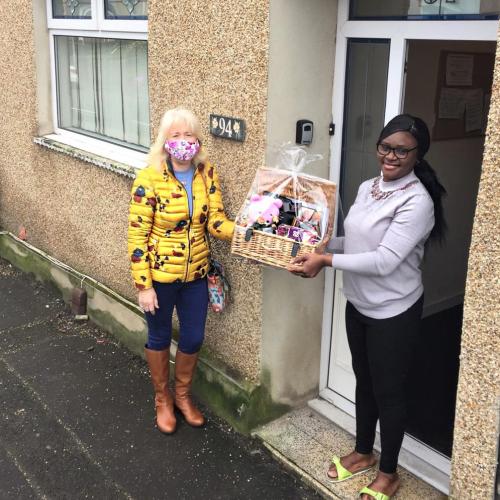 Friends on the doorstep exchanging flowers