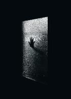 hand on a glass of a black door