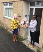 Friends on the doorstep exchanging flowers