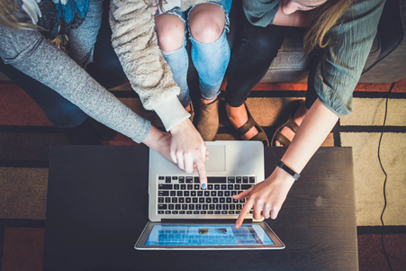 Group of students pointing at a laptop screen