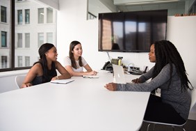 three students sit around a table