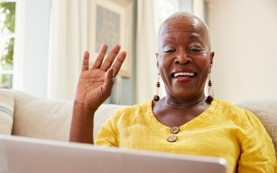 Photo of woman waving at laptop