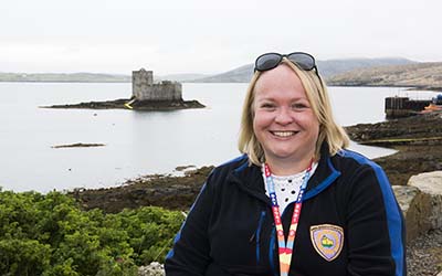 OU student Sarah at Castlebay, with the sea and castle in the background. Photo by Leila Angus.