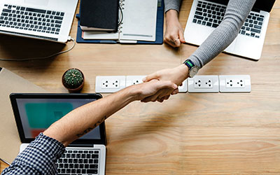 Photo of two people shaking hands across a table