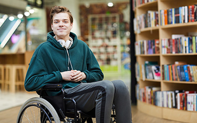 A smiling young man sitting in a wheelchair