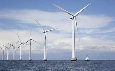 Wind turbines in the sea, and a sailing boat