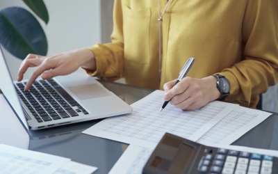 A person working on a financial document with their laptop