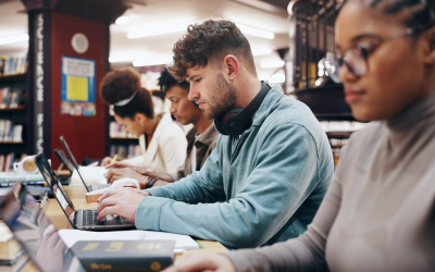 Students studying on their laptops in a library.