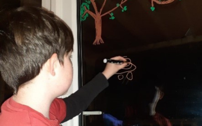 Photo of a child drawing on a blackboard.