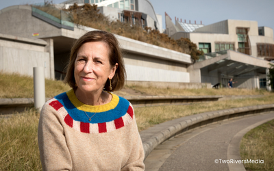 Presenter Kirsty Wark sitting in front of the Scottish Parliament building