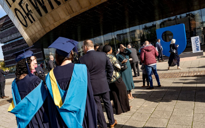Graduates standing in front of Wales Millenium Centre